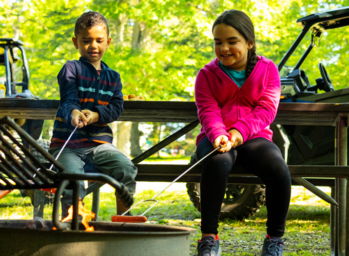 kids roasting hot dogs over fire