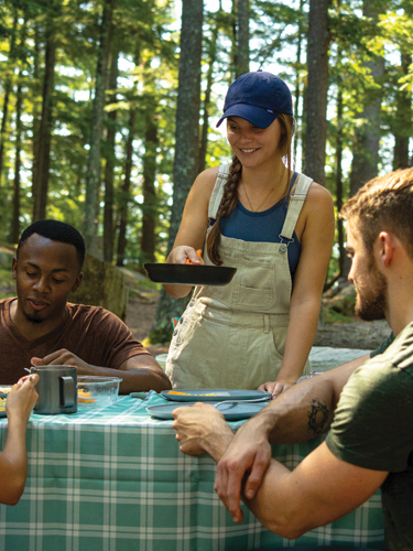 millennials cooking at campsite