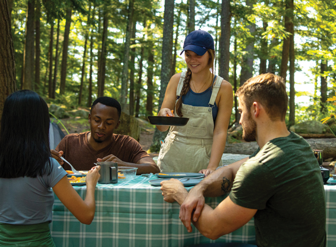 millennials cooking at campsite
