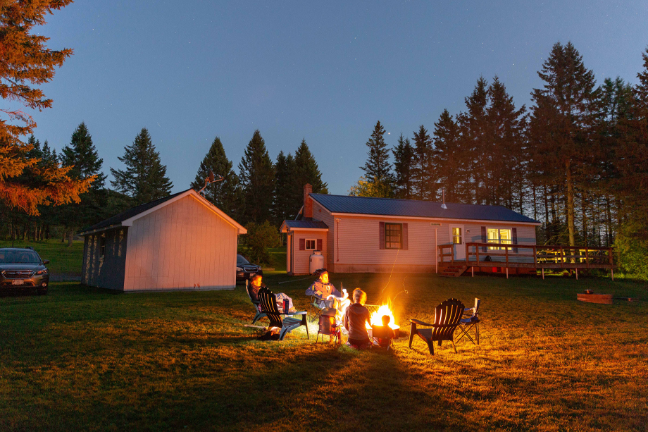 coleman lodges at night with campfire