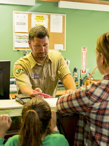 Male NH State Park employee at check-in desk