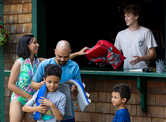 employee with lifejacket rentals at boathouse