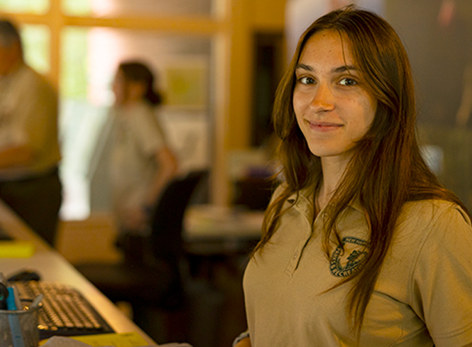 young woman employee at front desk check in 