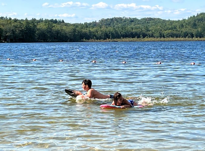 two kids swimming with floats at greenfield state park