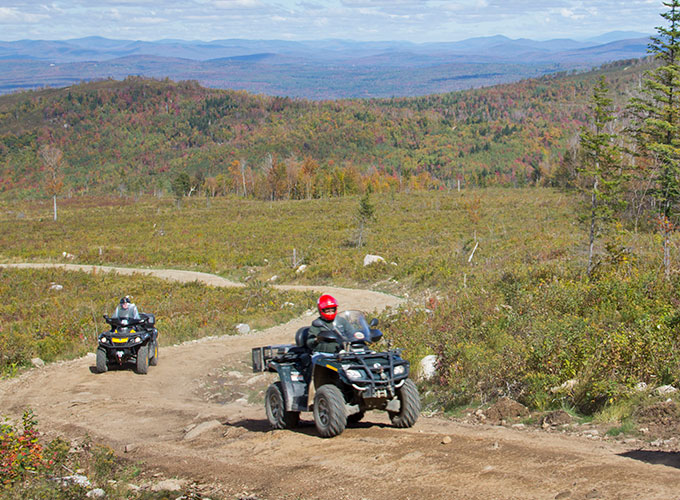 people riding off road recreational vehicles through a park