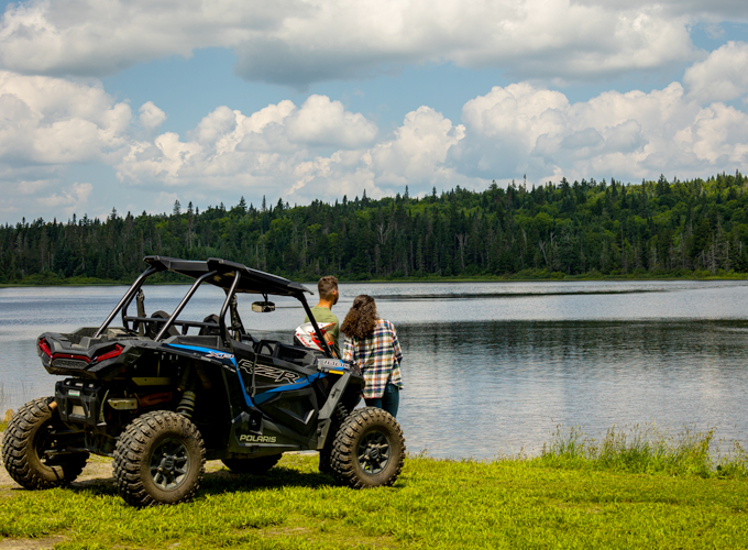 young couple ohrving taking break by a lake