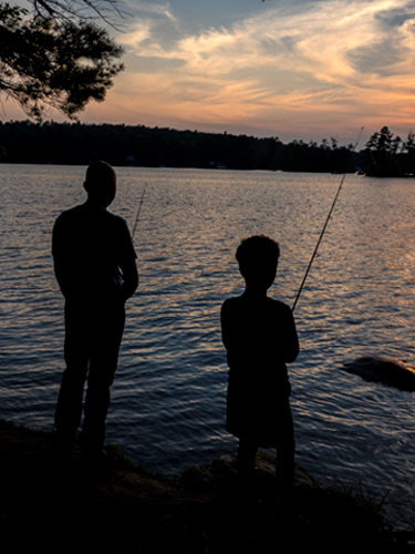 father and son fishing at sunset at pawtuckaway state park