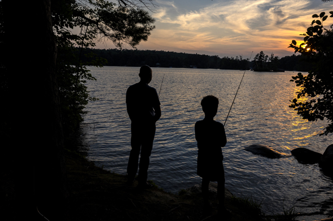 father and son fishing at sunset at pawtuckaway state park