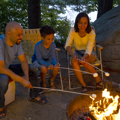 family toasting marshmallows at campsite