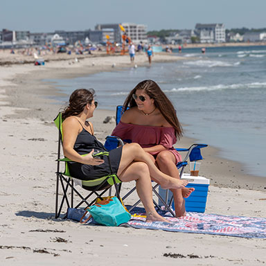 Women sitting on chairs at Hampton Beach