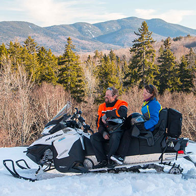 People snowmobiling on a trail