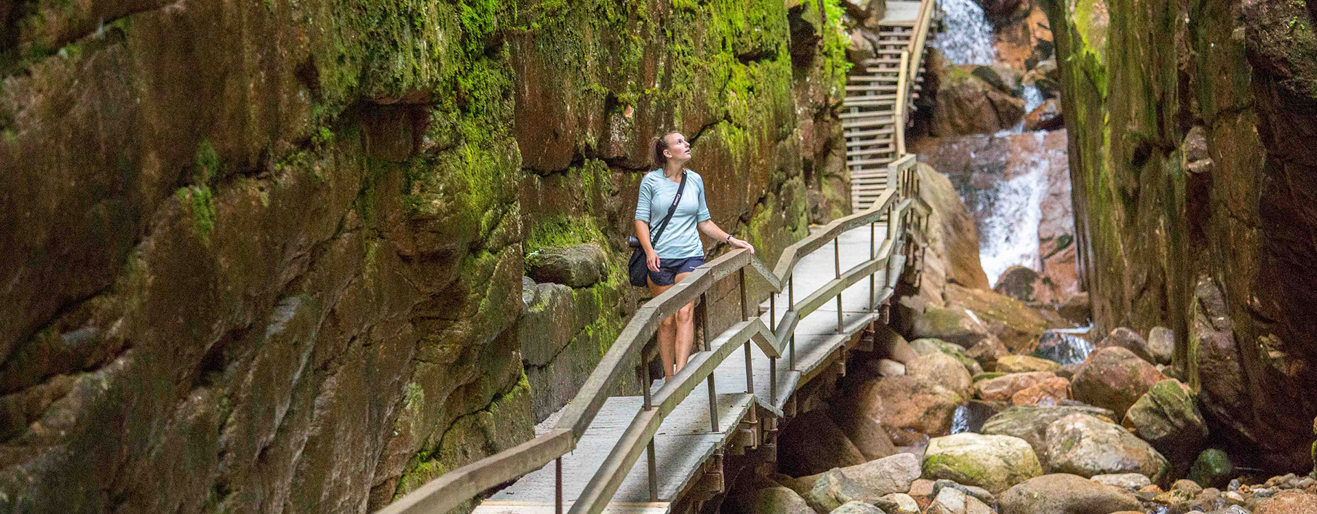 Woman walking on the boardwalk through Flume Gorge