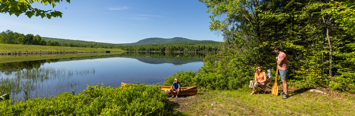 Lake with mountains in background father and son with canoe
