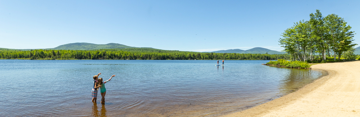 kids in the lake at jericho mountain state park with SUPs int eh backgrounds
