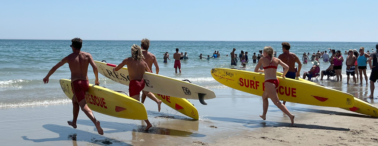 lifeguards running with surfboards
