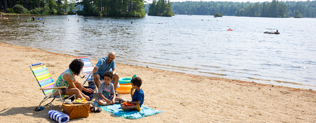 family at the beach at pawtuckaway state park