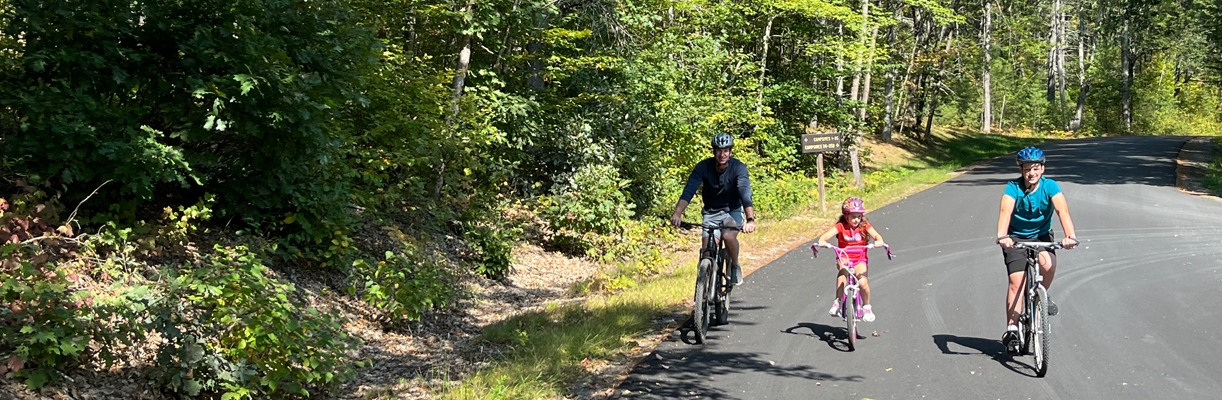 father and two kids bike riding at greenfield state park