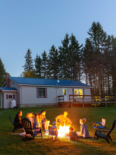 family around at campfire at coleman lodges