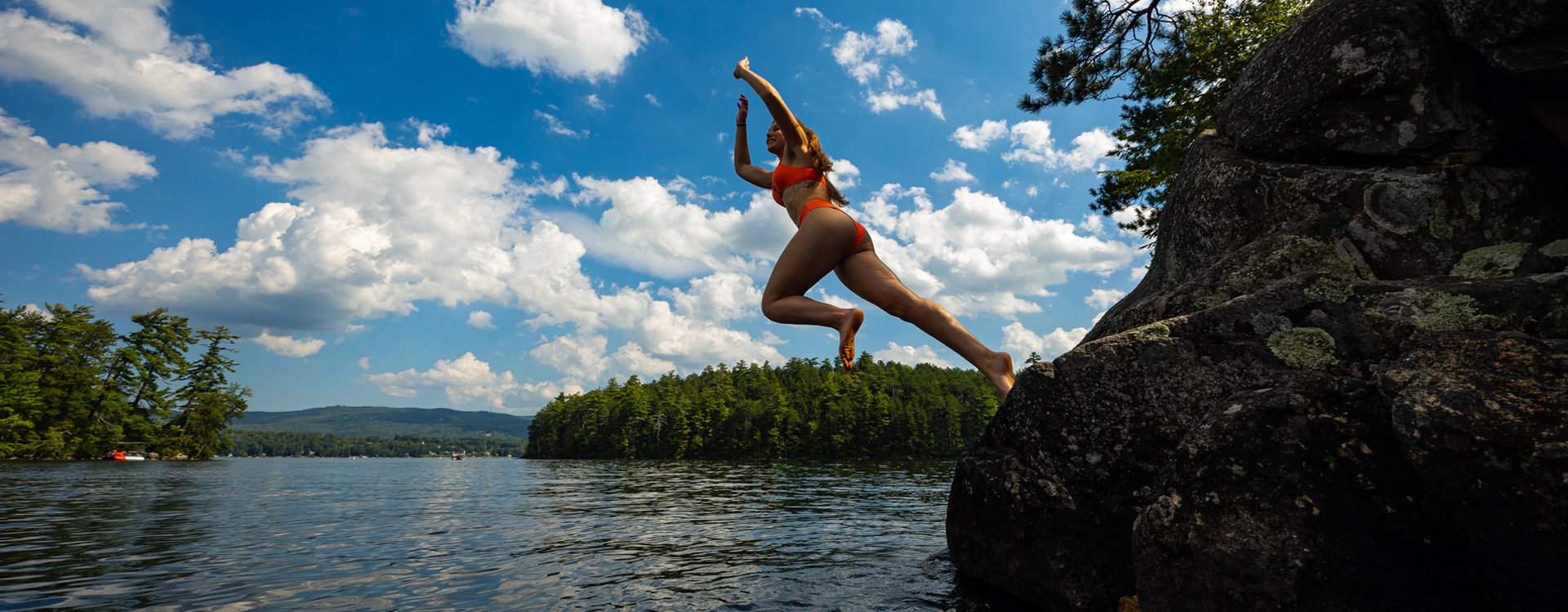 young woman jumping into the water at wellington state park