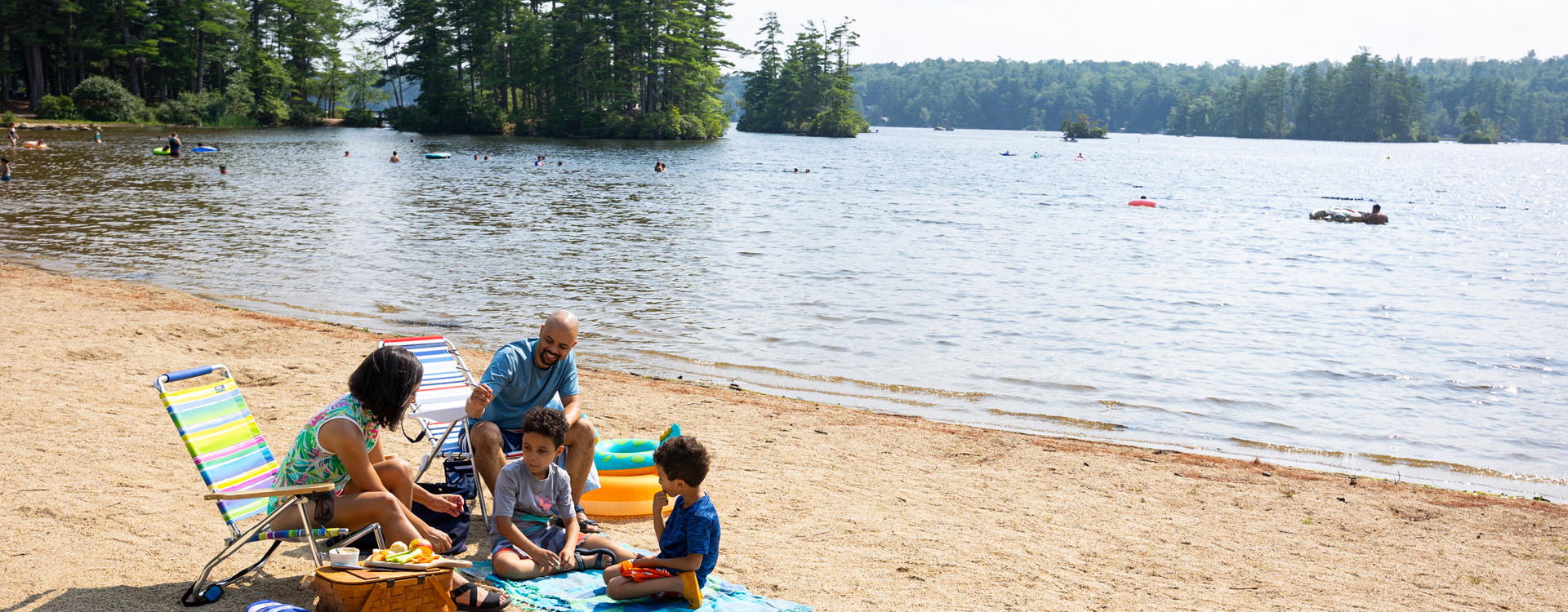 young family on the beach at pawtuckaway state park