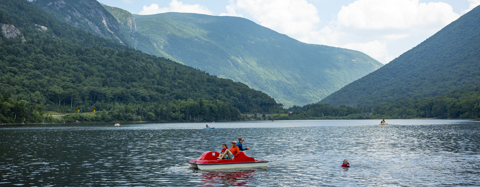 people on pedal boat  echo lake beach at franconia notch state park in summer