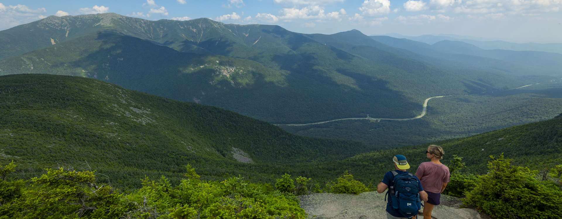 couple hiking the rim trail on cannon mountain with scenic vista