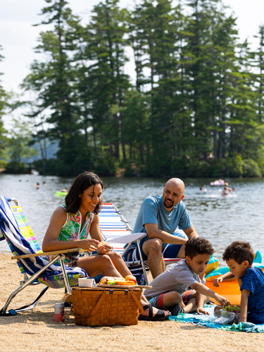 young family on the beach at pawtuckaway state park