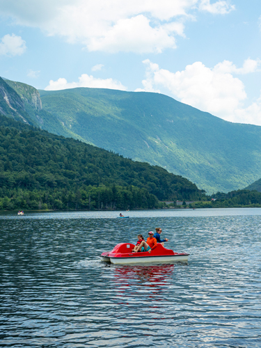 people on pedal boat  echo lake beach at franconia notch state park in summer