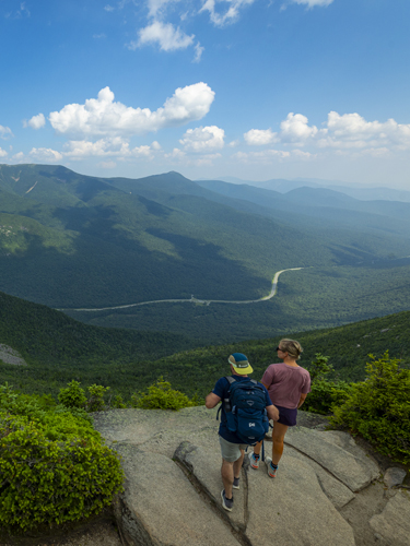 couple hiking the rim trail on cannon mountain with scenic vista