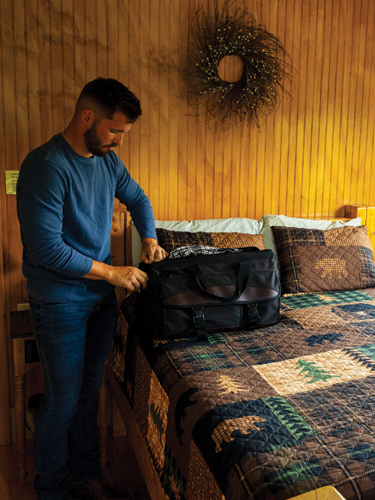 young man unpacking inside coleman lodge