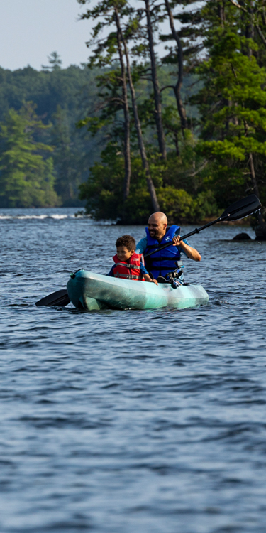 father and son kayaking at pawtuckaway state park