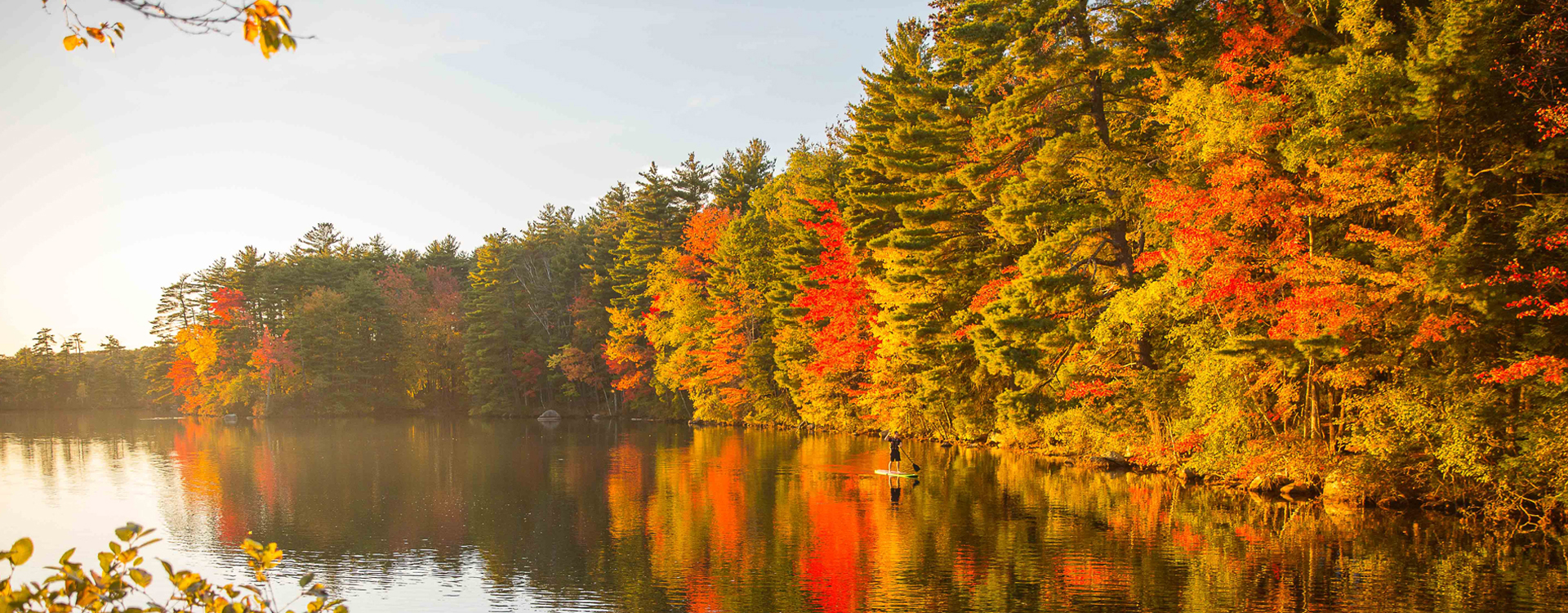 young man kayaking at pawtuckaway state park in autumn