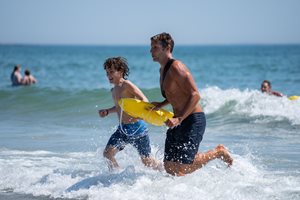 lifeguard running with boy in water
