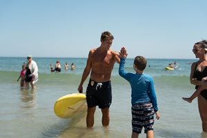 lifeguard high-fiving with boy at water safety day