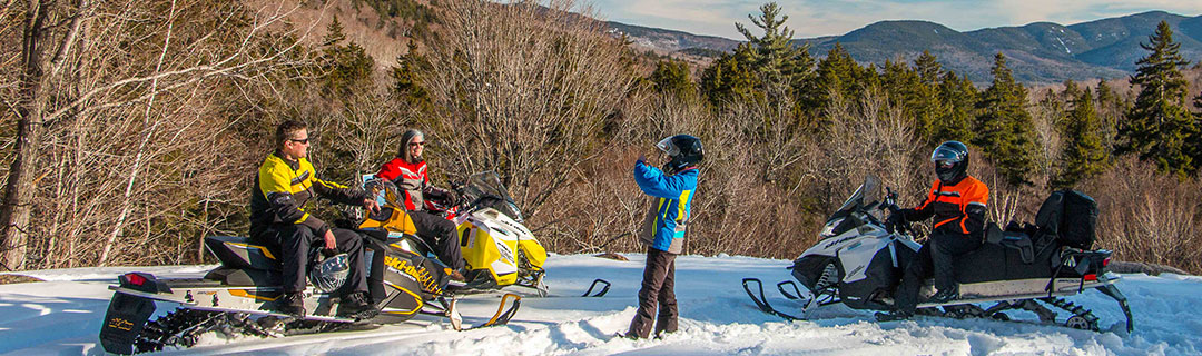 People snowmobiling on a trail